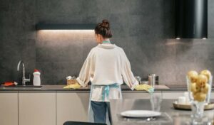 Woman from backside standing in her kitchen