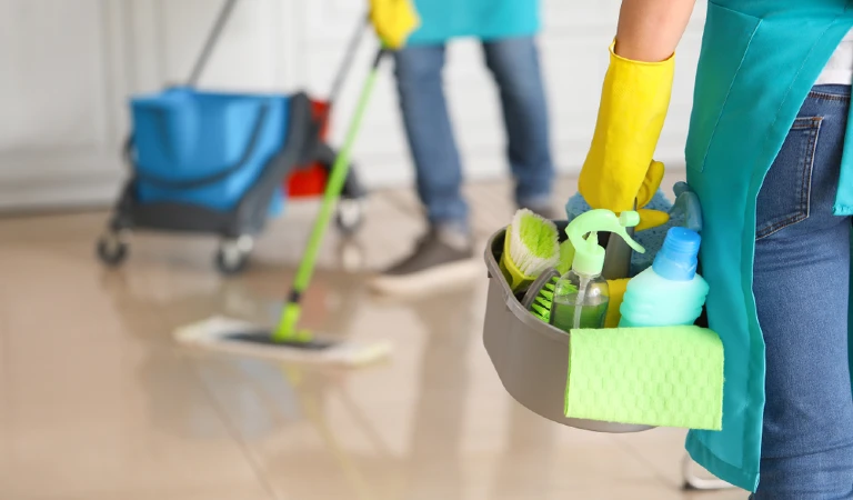 Cleaners holdoing supplies and cleaning the floor