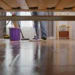 Washing with a mop in the house, view from under the sofa