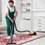 Dry cleaner's employee hoovering carpet with vacuum cleaner in room