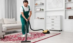 Dry cleaner's employee hoovering carpet with vacuum cleaner in room