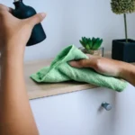 Female hand using microfiber cloth cleaning cupboard surface at home