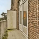 Balcony with concrete floor with rusty metal fence and metal drill and salt air rust stains on metal