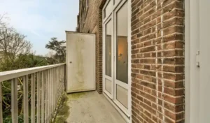 Balcony with concrete floor with rusty metal fence and metal drill and salt air rust stains on metal